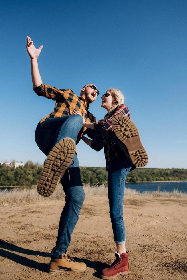 Guy and girl in caged shirts and trekking shoes photo