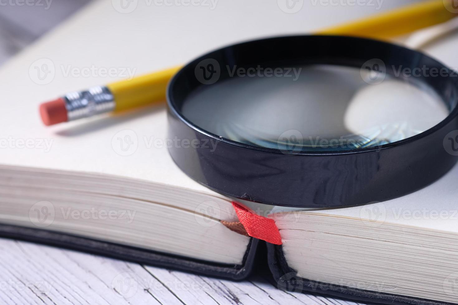 Close up of open book and magnifying glass photo