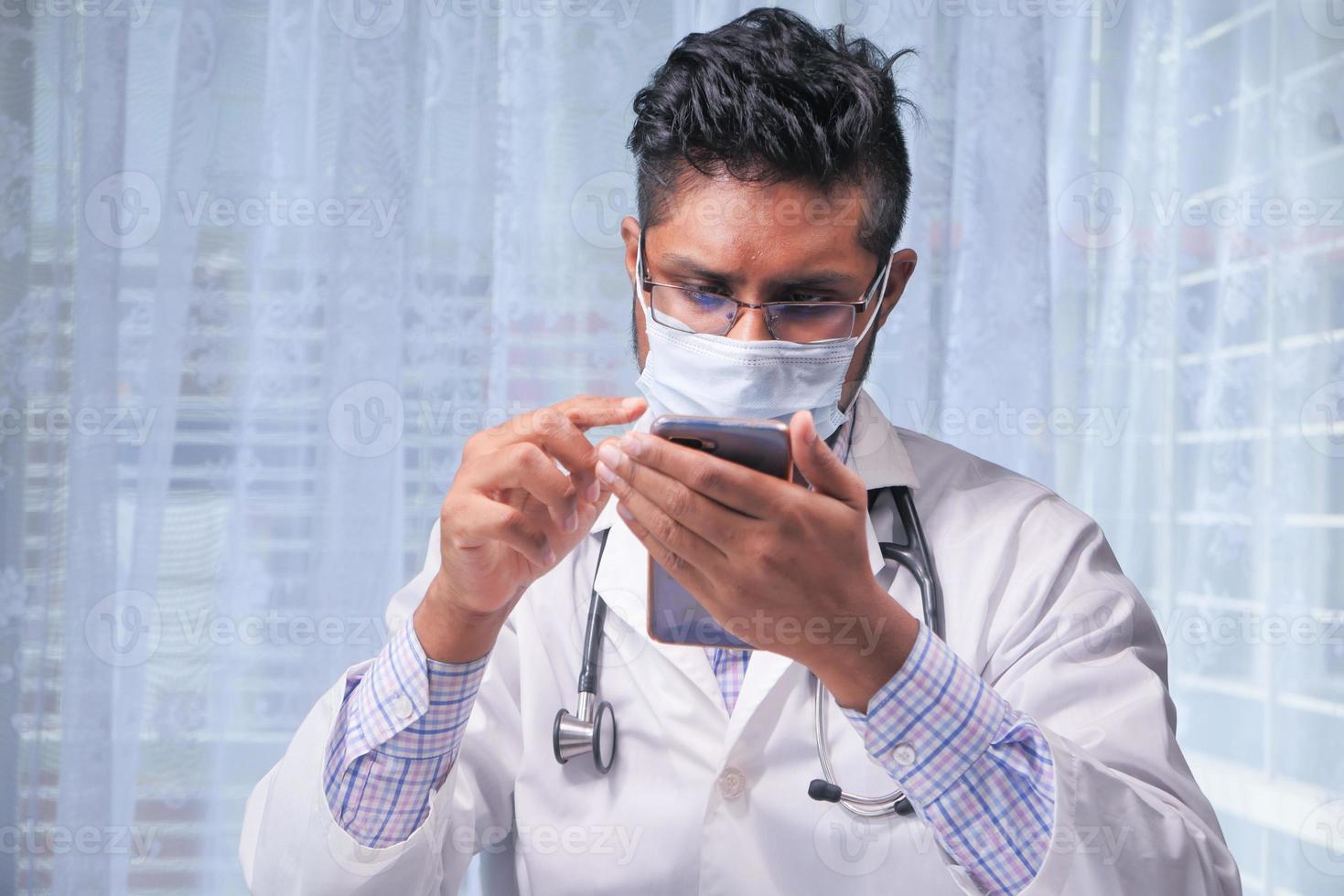 doctor usando un teléfono inteligente en el hospital foto