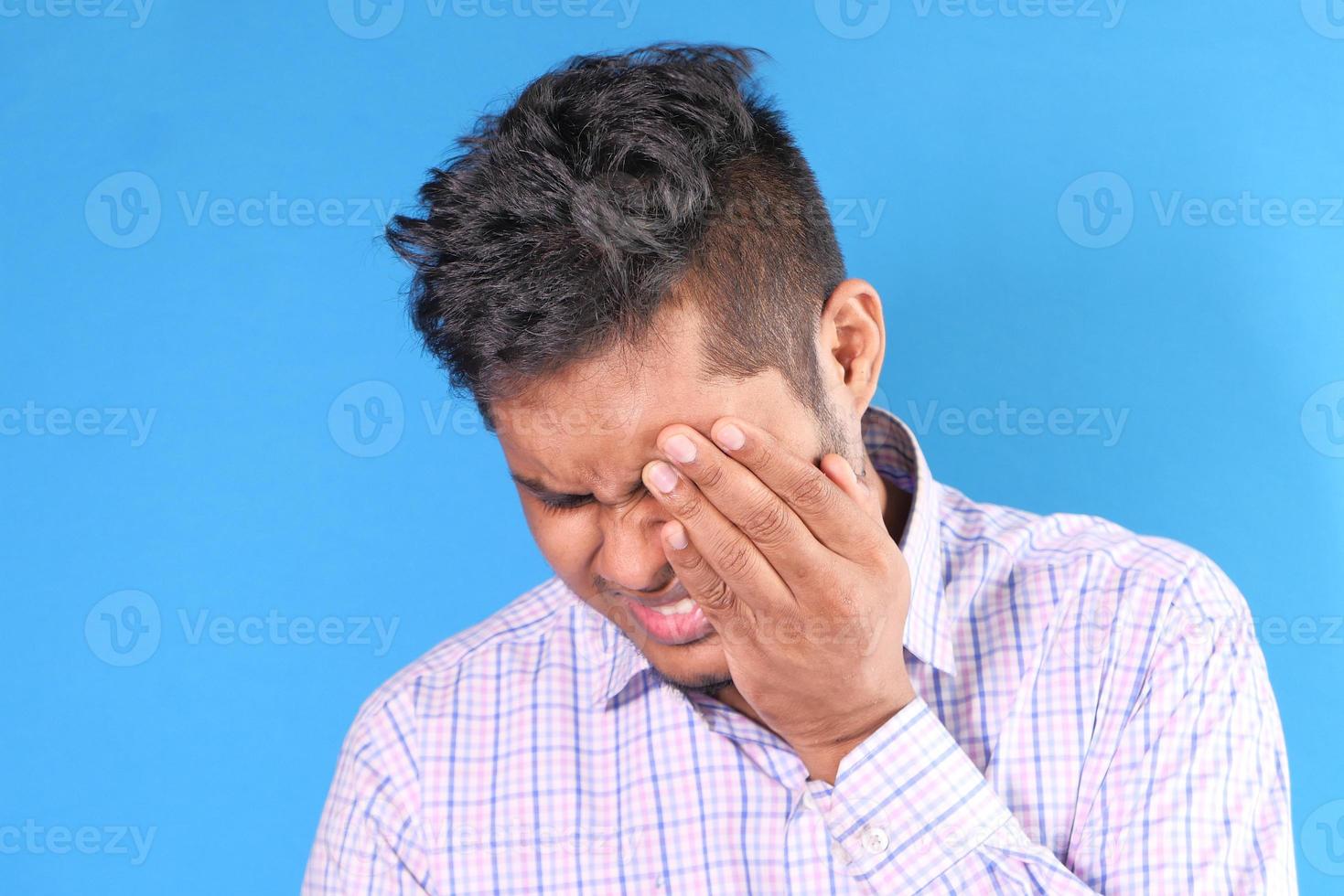 Man holding eye in pain photo