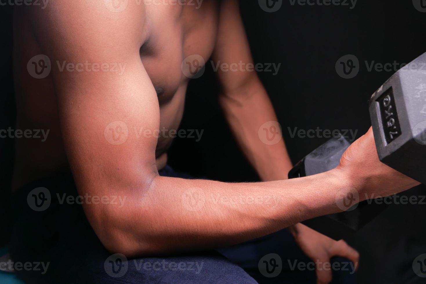 Man exercising biceps with free weights photo