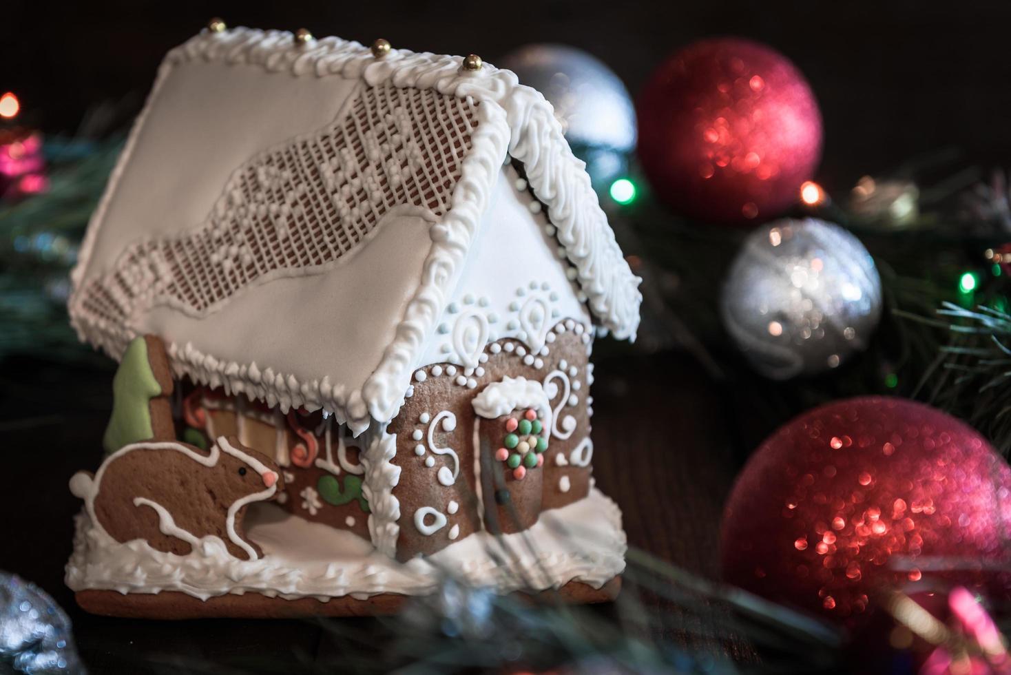 Gingerbread house in the white glaze on the background of the Christmas decorations photo