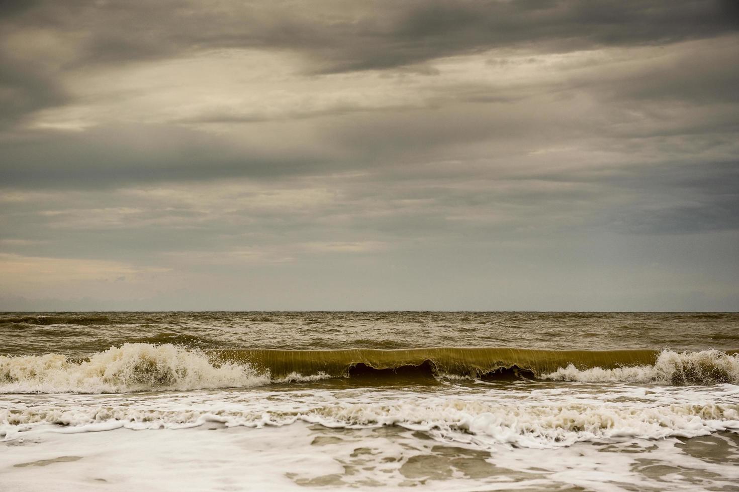 Sullen red sea covered by dark clouds photo