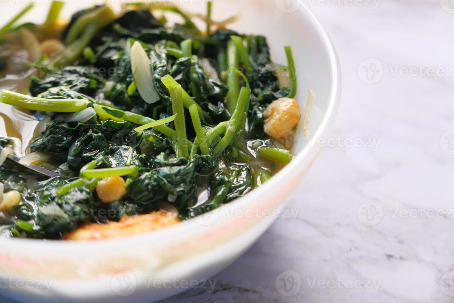 Close up of bowl with cooked spinach on table photo