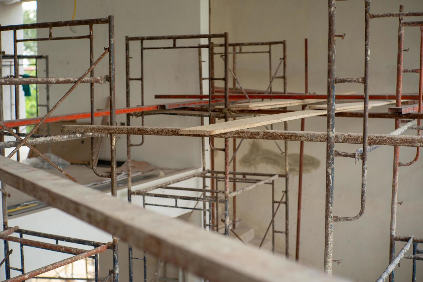 Placa de madera de enfoque selectivo en el andamio para trabajar a alto nivel en el sitio de construcción foto