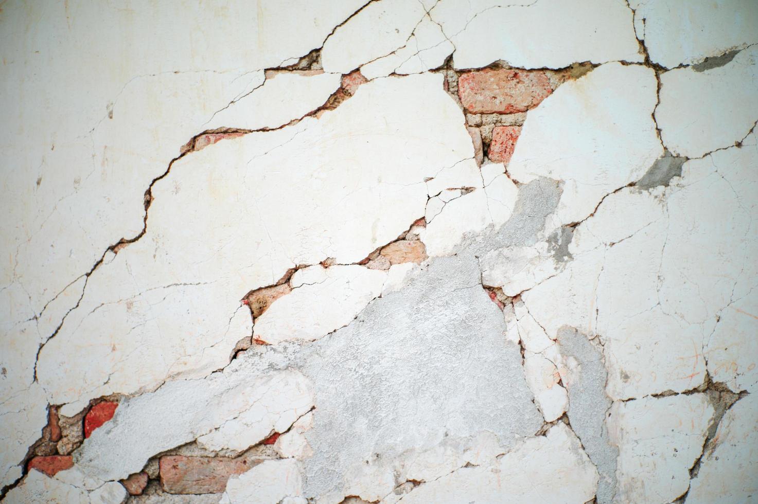 Textura abstracta y fondo de pared de cemento enlucido roto con albañiles rojos en el interior foto