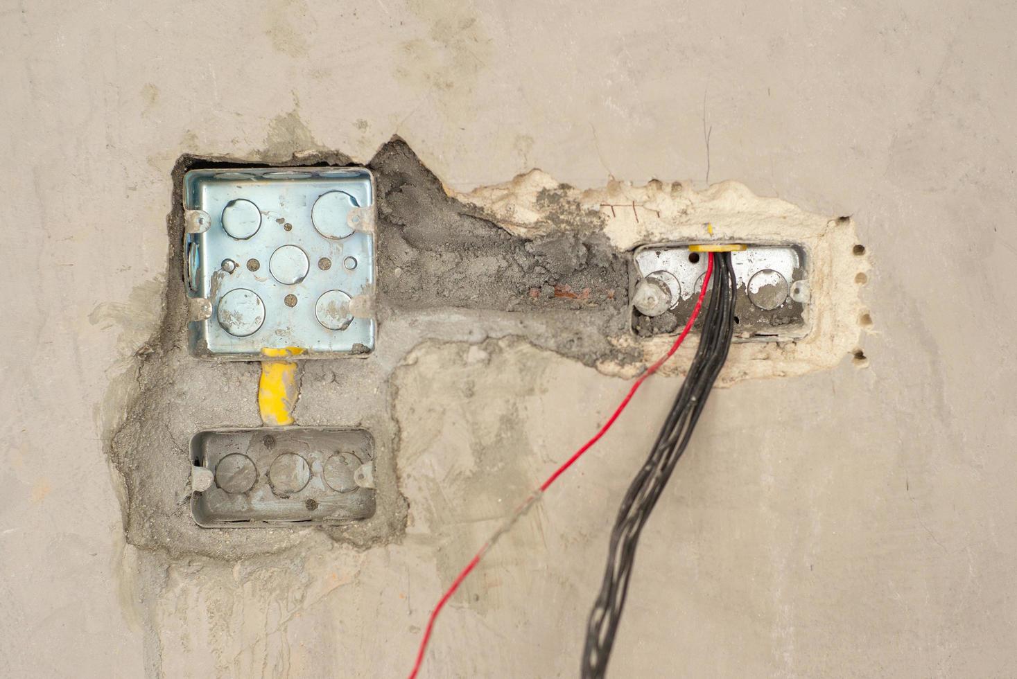 Primer plano de textura y fondo de bloque de metal para la instalación del sistema eléctrico en la pared de cemento enlucido en casa en construcción foto