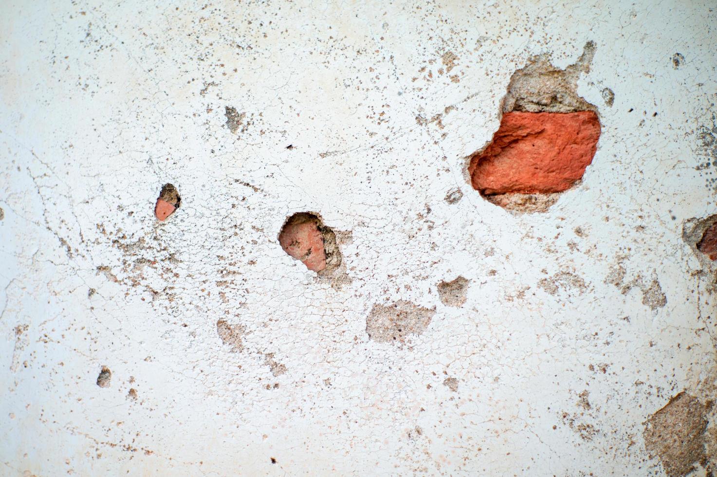 Textura abstracta y fondo de pared de cemento enlucido roto con albañiles rojos en el interior foto