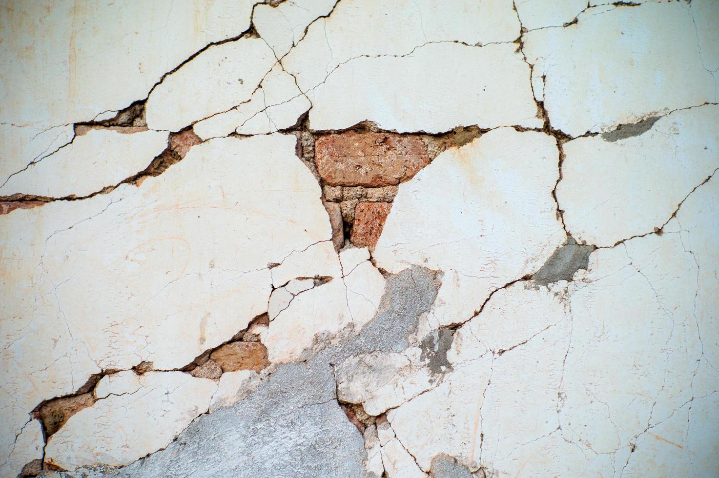 Textura abstracta y fondo de pared de cemento enlucido roto con albañiles rojos en el interior foto