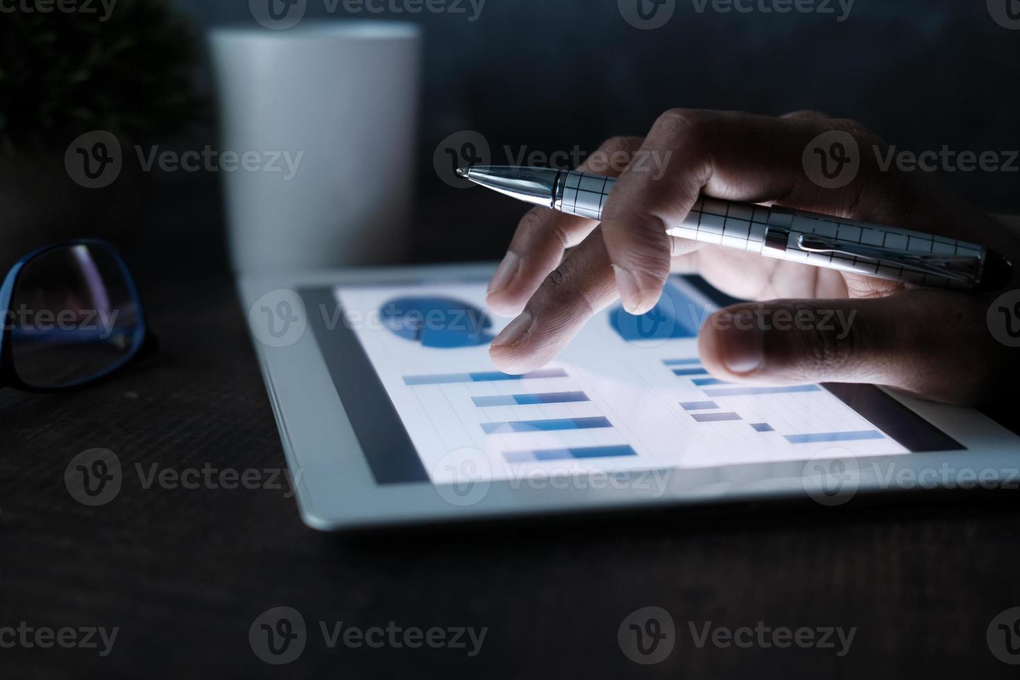 Man using a digital tablet in the dark photo