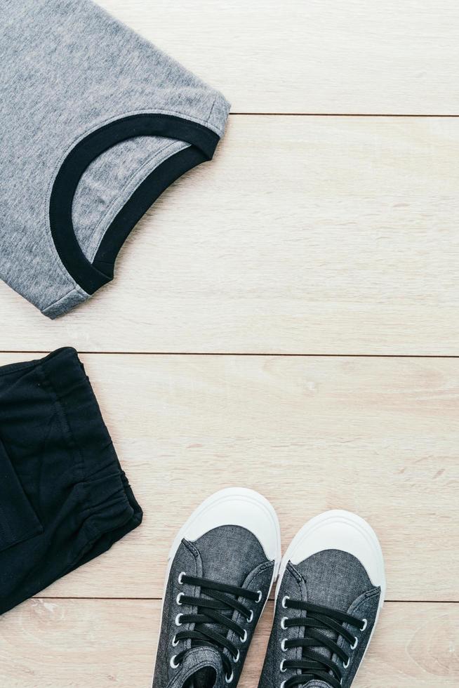 T-shirt with pants and shoes on wooden background photo