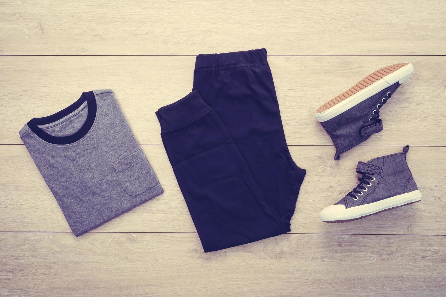 T-shirt with pants and shoes on wooden background photo