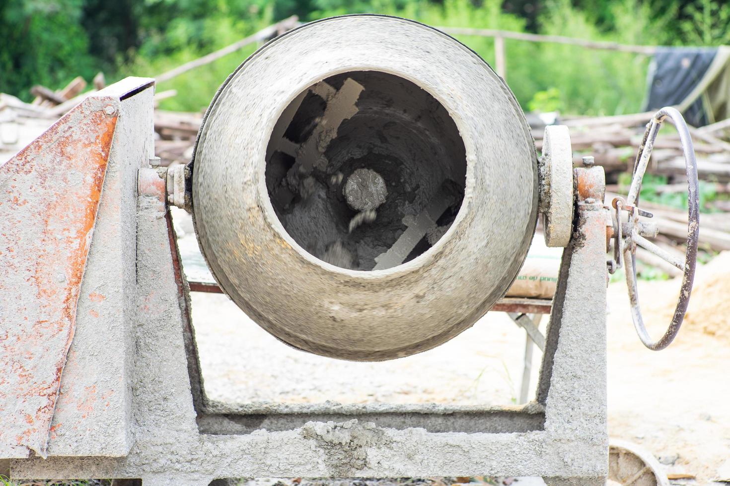 Closeup picture of dirty concrete mixer working at the construction site photo