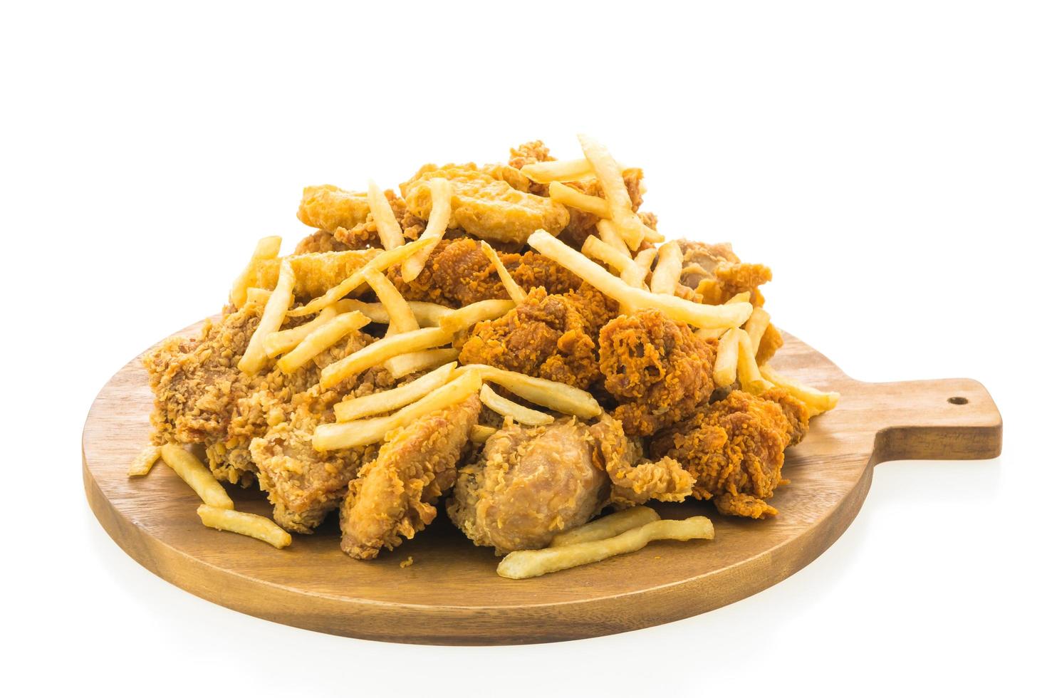 French fries and fried chicken on wooden plate photo