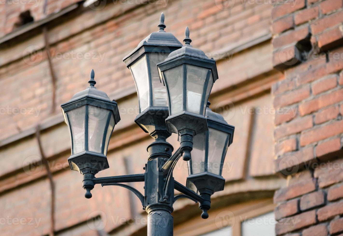 Lantern against a brick wall photo