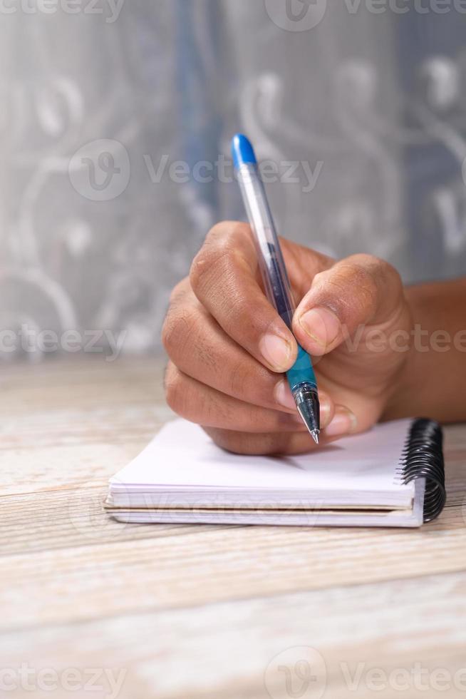 Close up of man writing on notepad photo