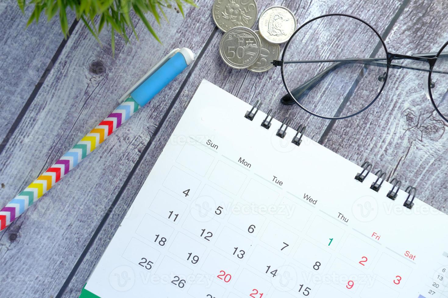 Calendar and pen on wooden desk photo