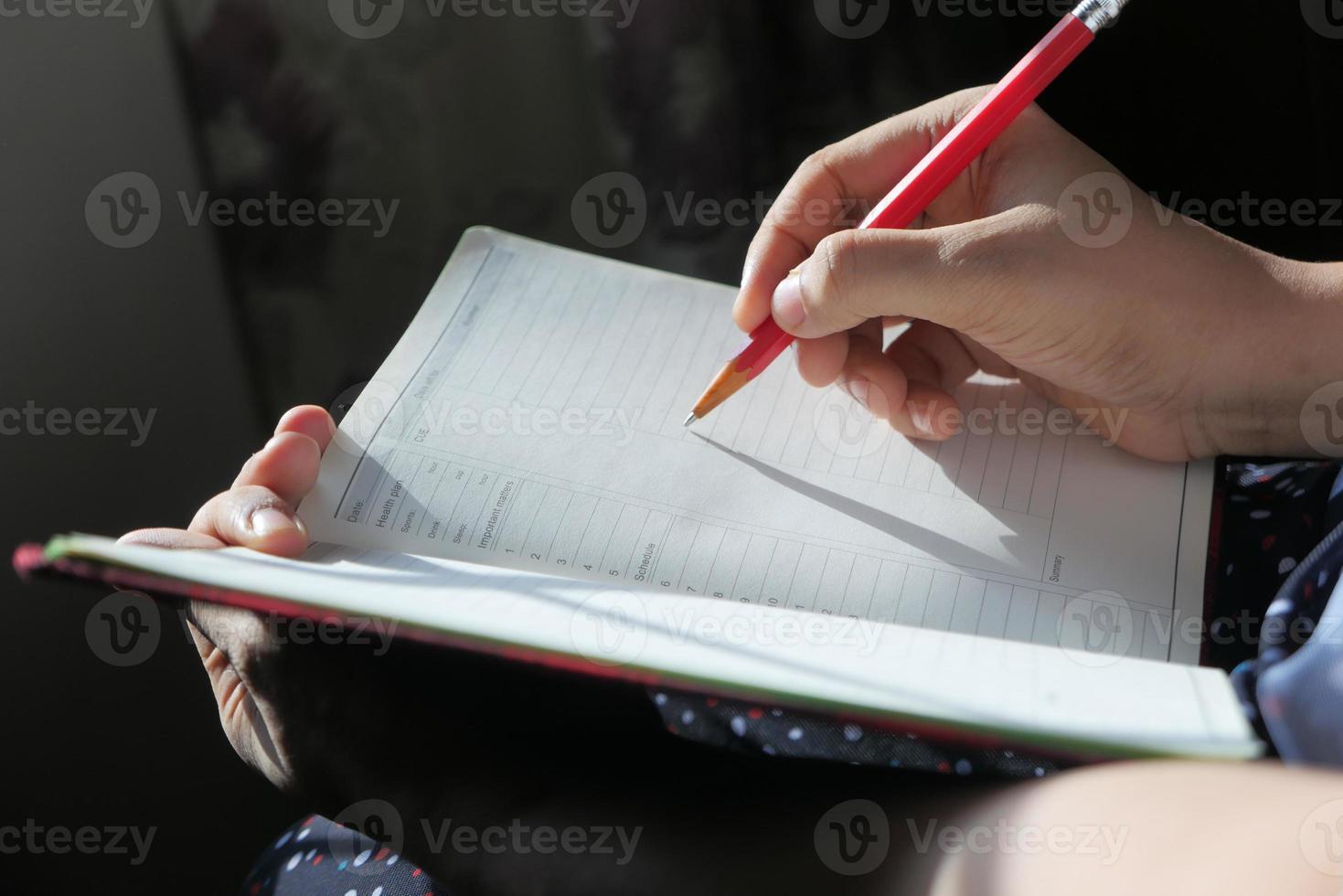 persona escribiendo en un diario foto