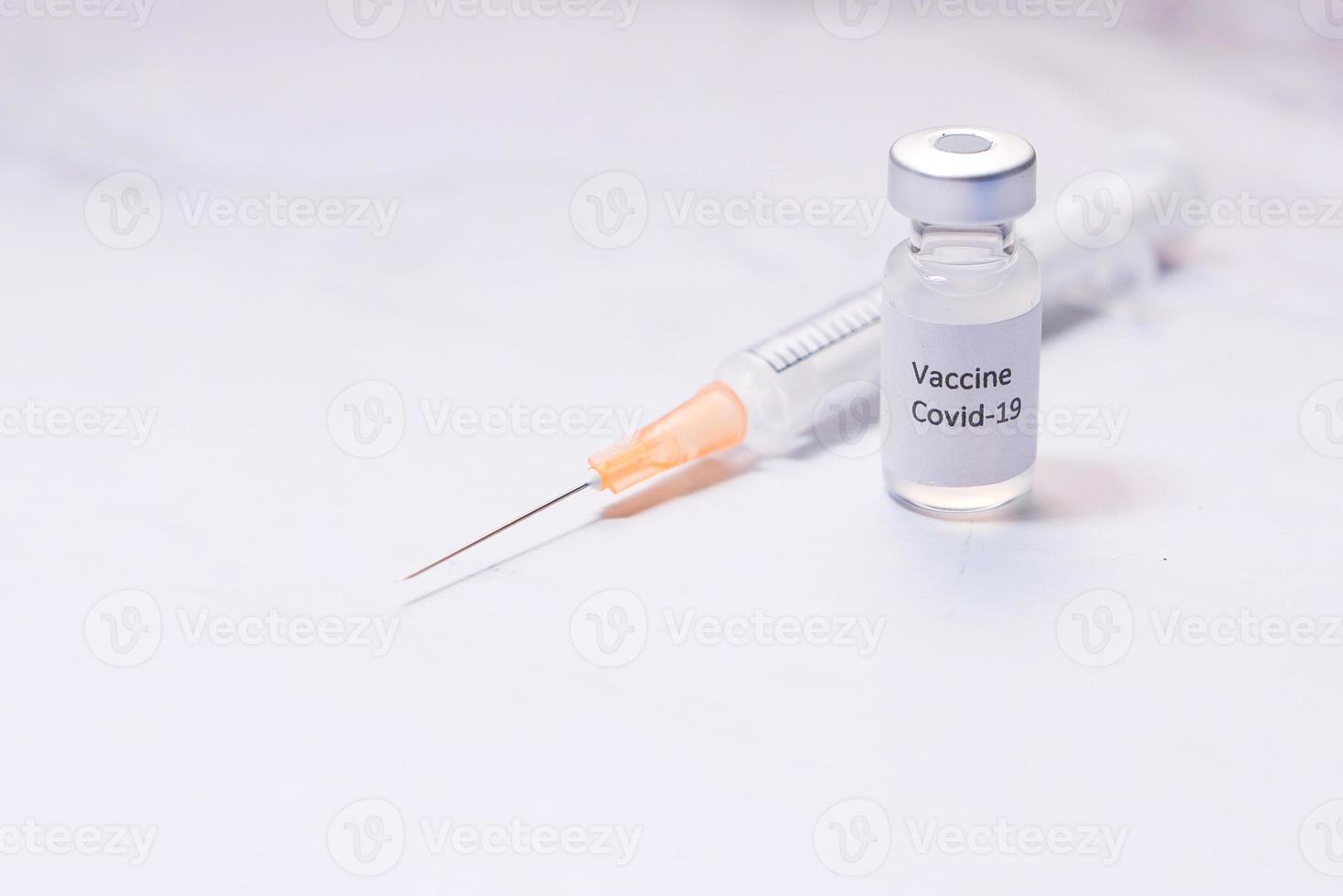 Close up of coronavirus vaccine and syringe on white background photo