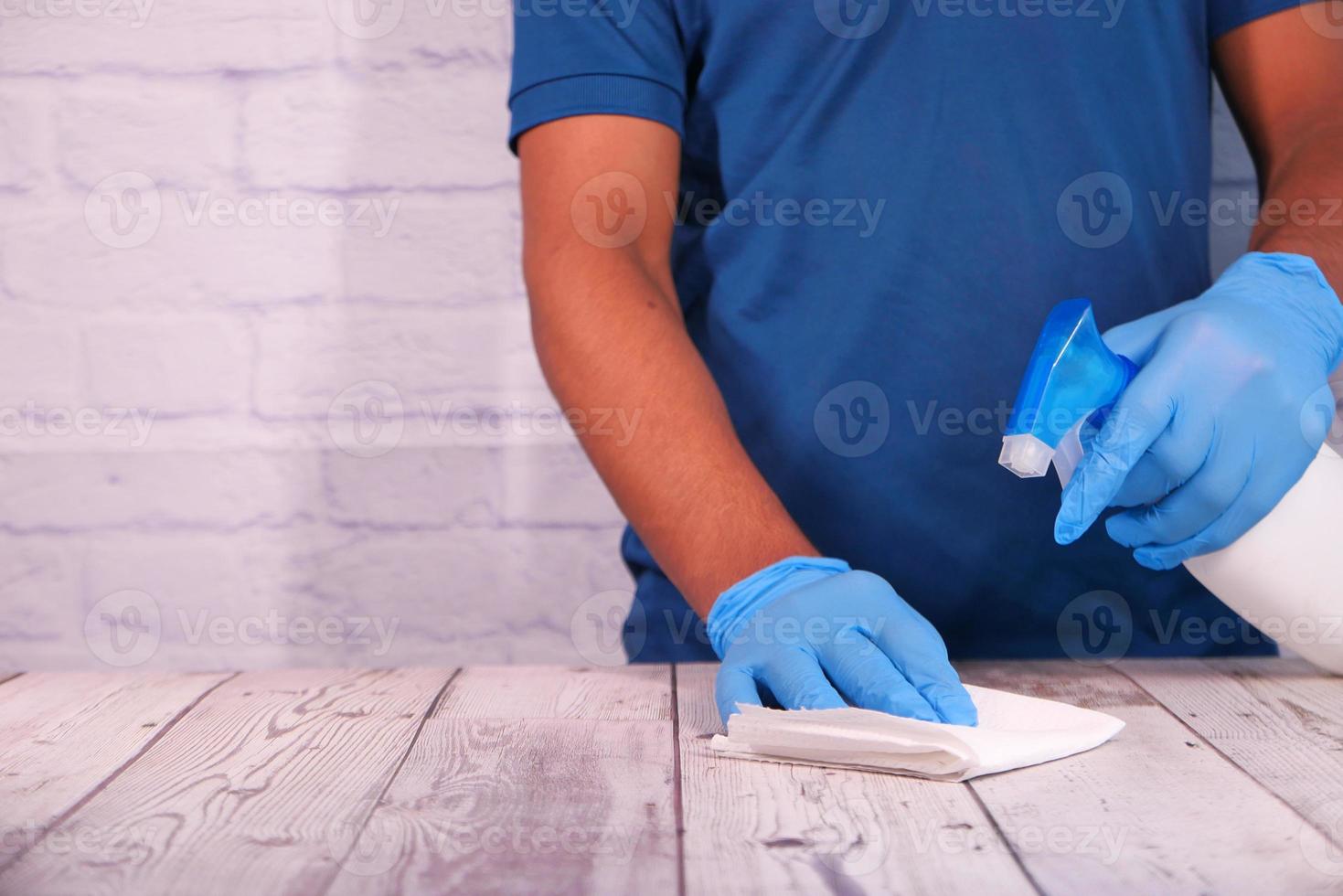 Person using disinfectant spray to clean table surface 2238639 Stock