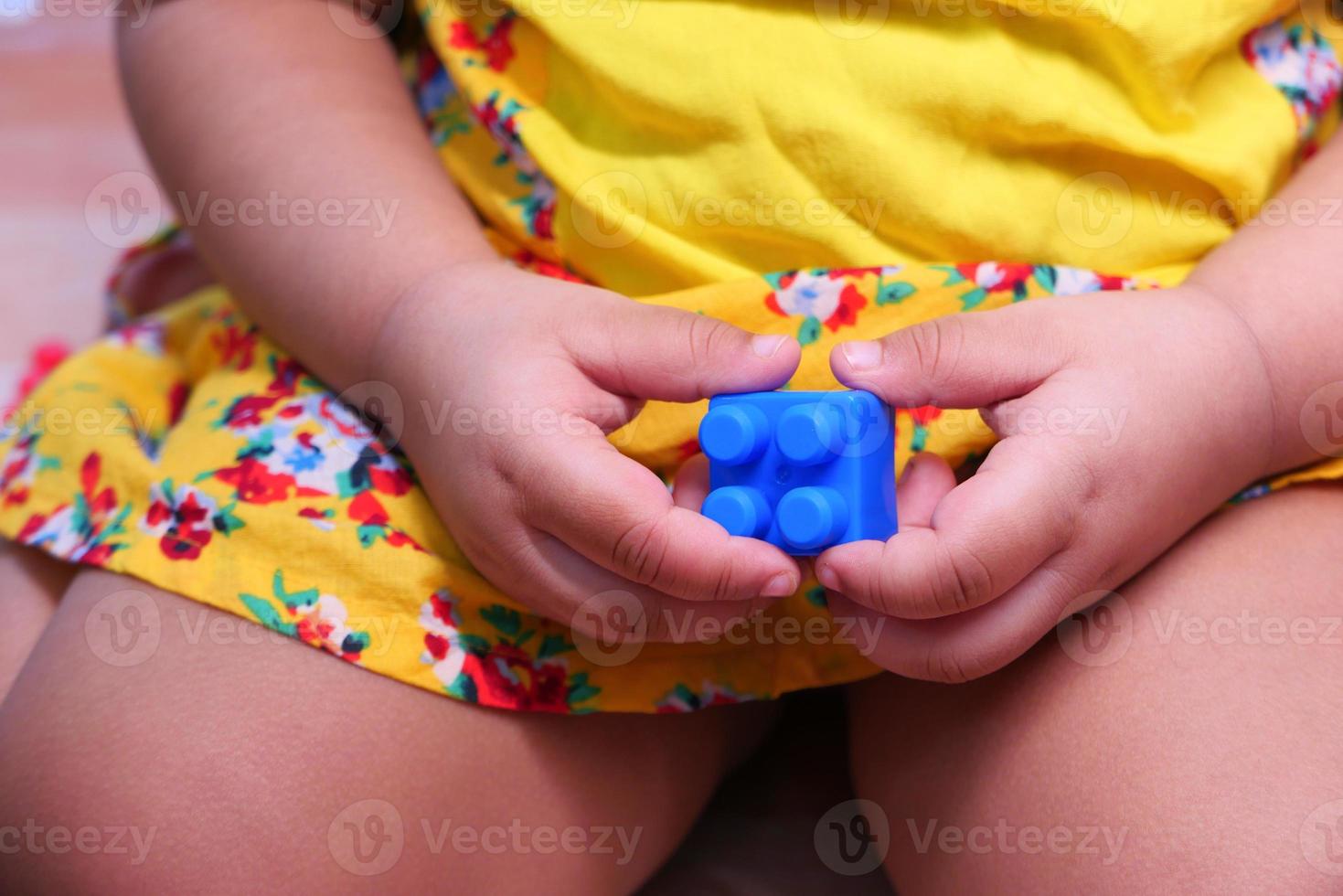 niño sosteniendo un bloque azul foto