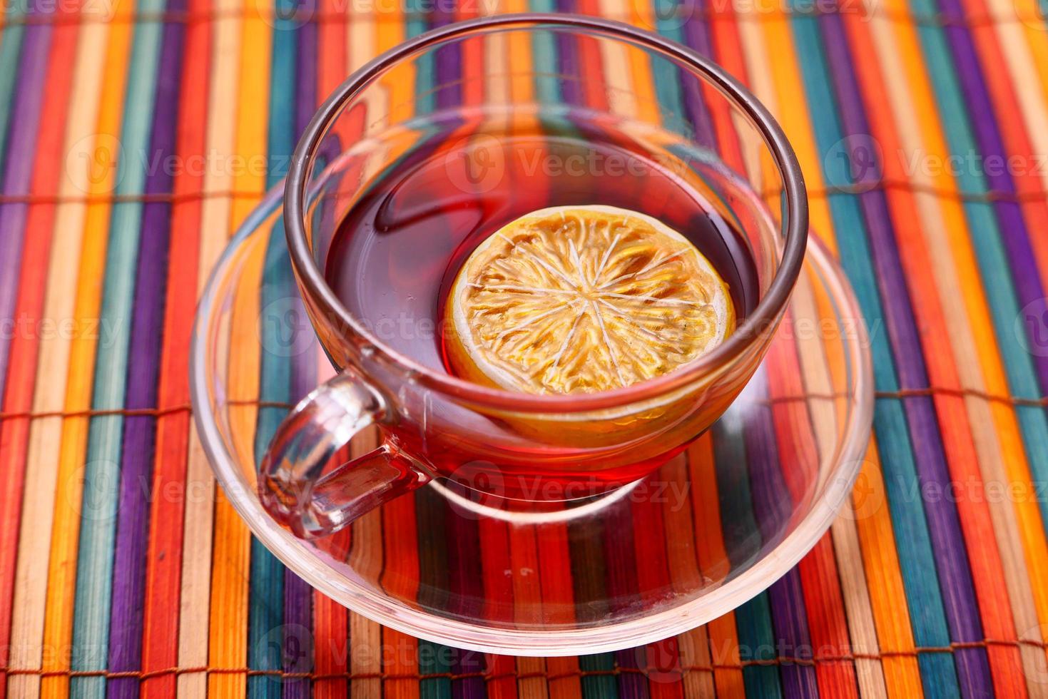Lemon tea on colorful tablecloth background photo