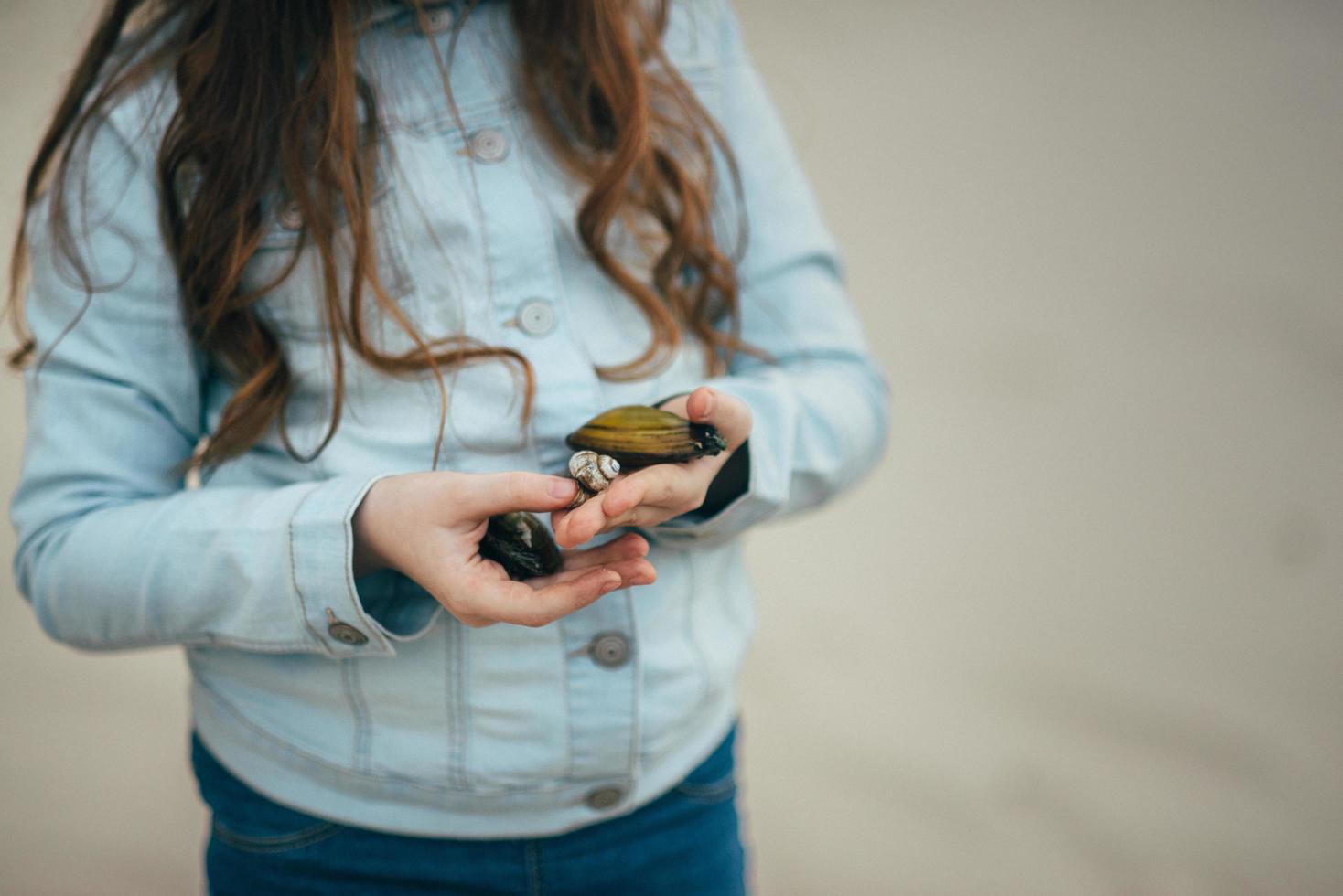 niña sosteniendo mejillones en sus manos foto