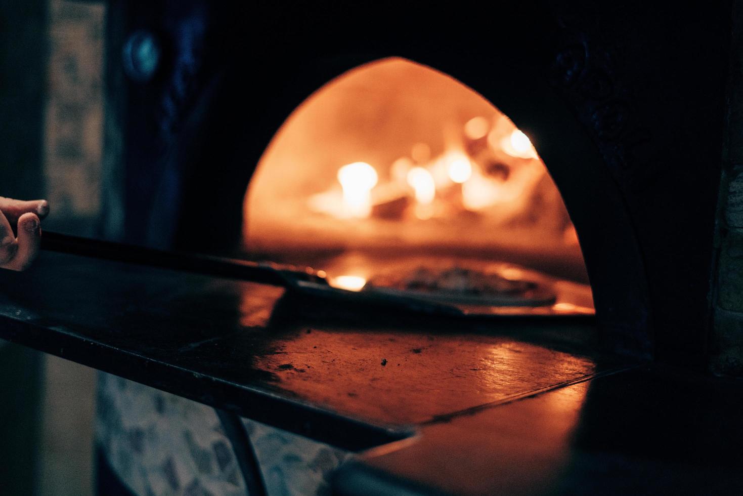 pizza colocada en un horno de pizza foto