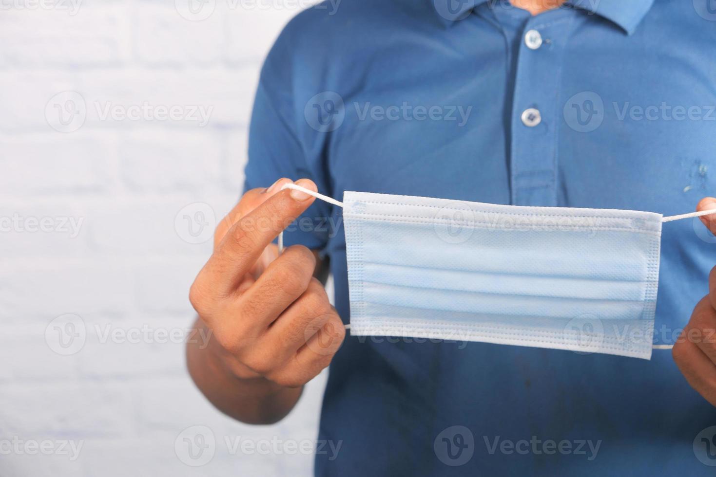 Man holding surgical face mask, close up photo