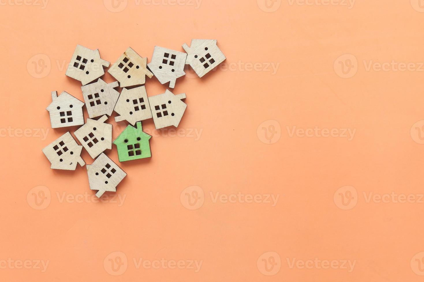 Small model houses on orange background photo