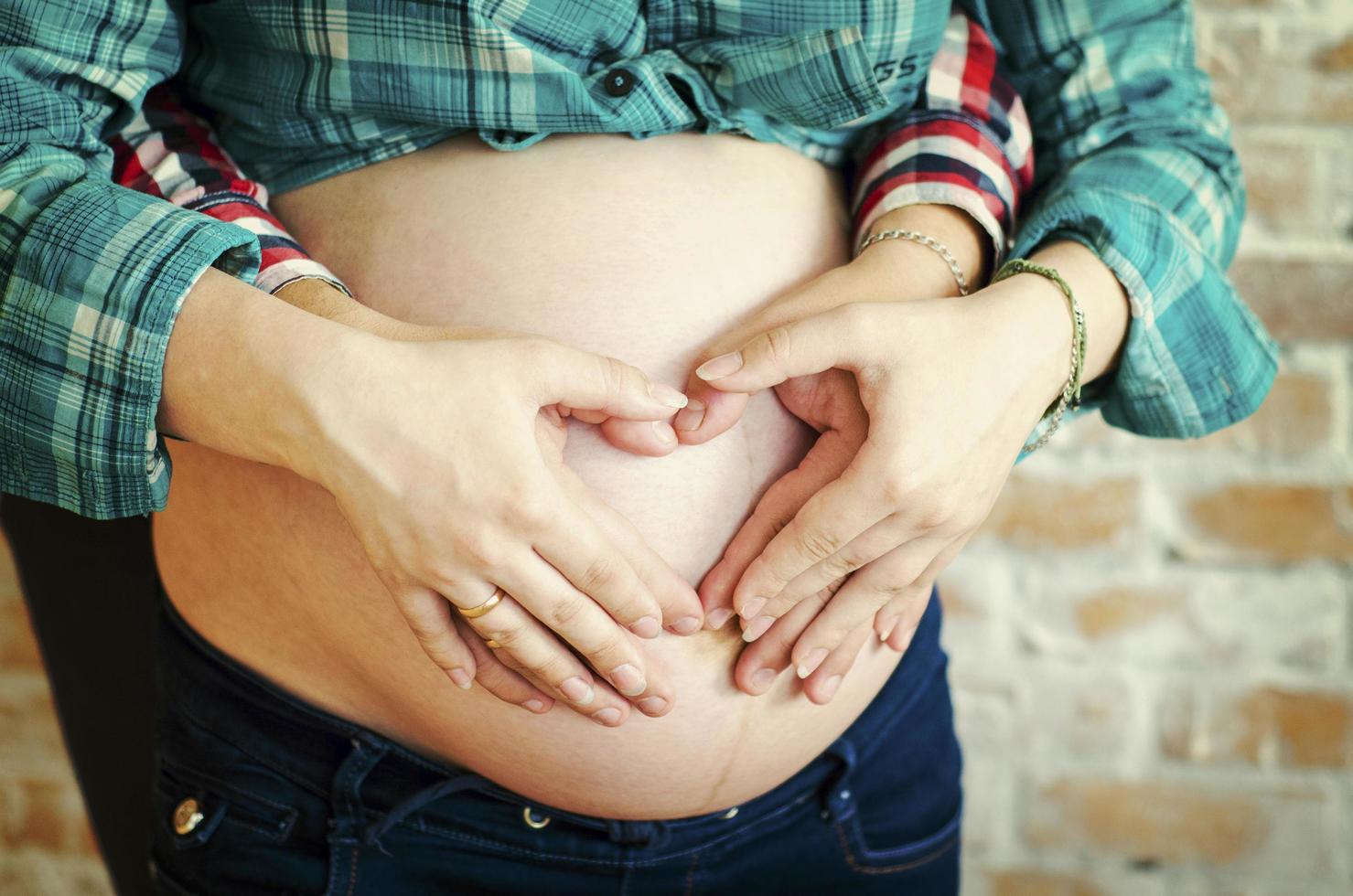 Pregnant couple with hands on belly photo