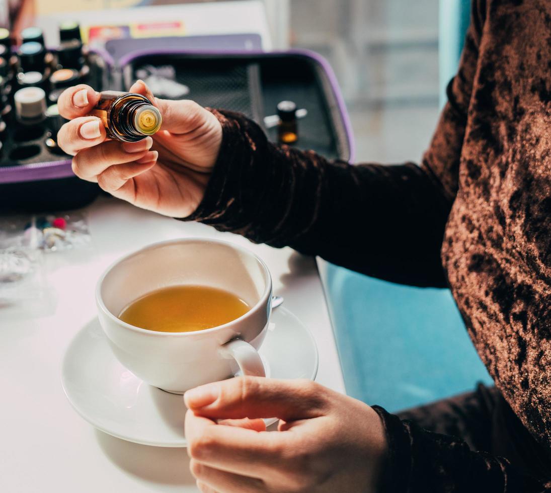 Adding oil to herbal tea photo