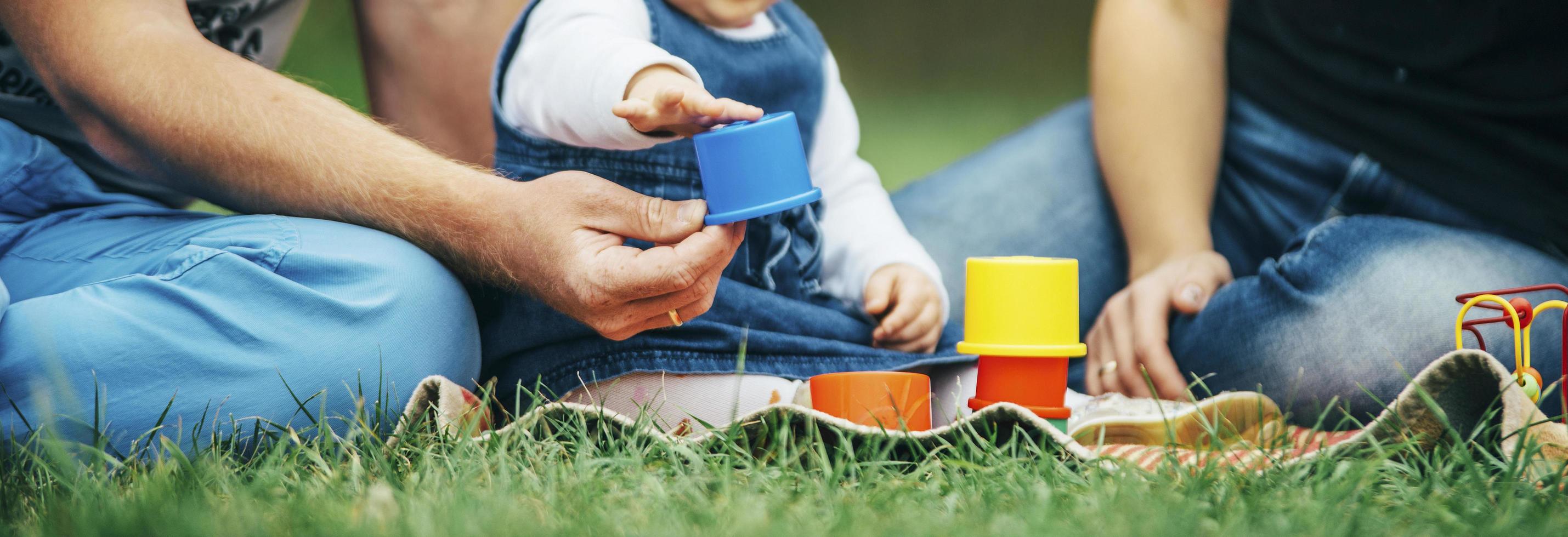 Parents playing with child in a park photo