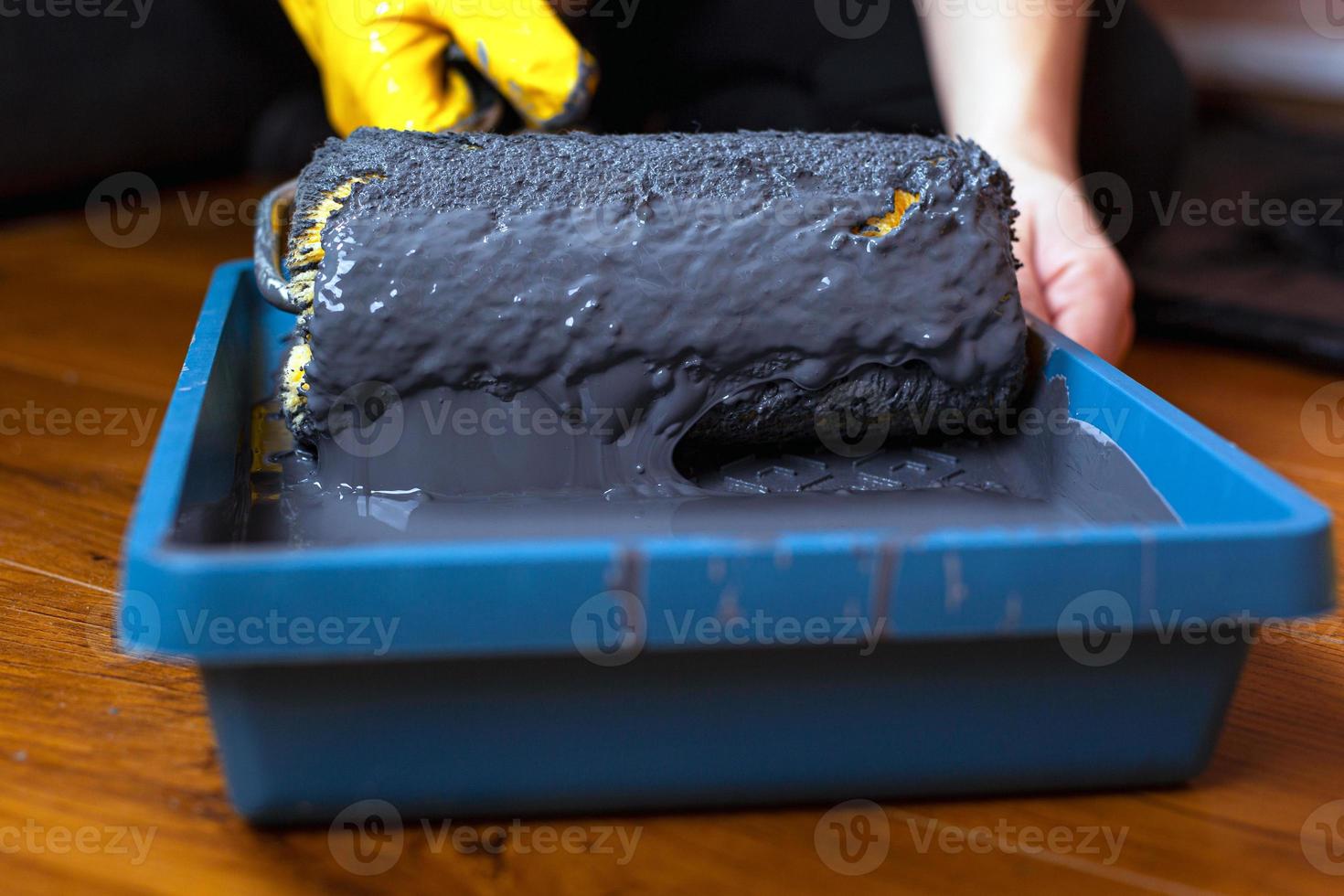 Roller in a tray with gray paint photo