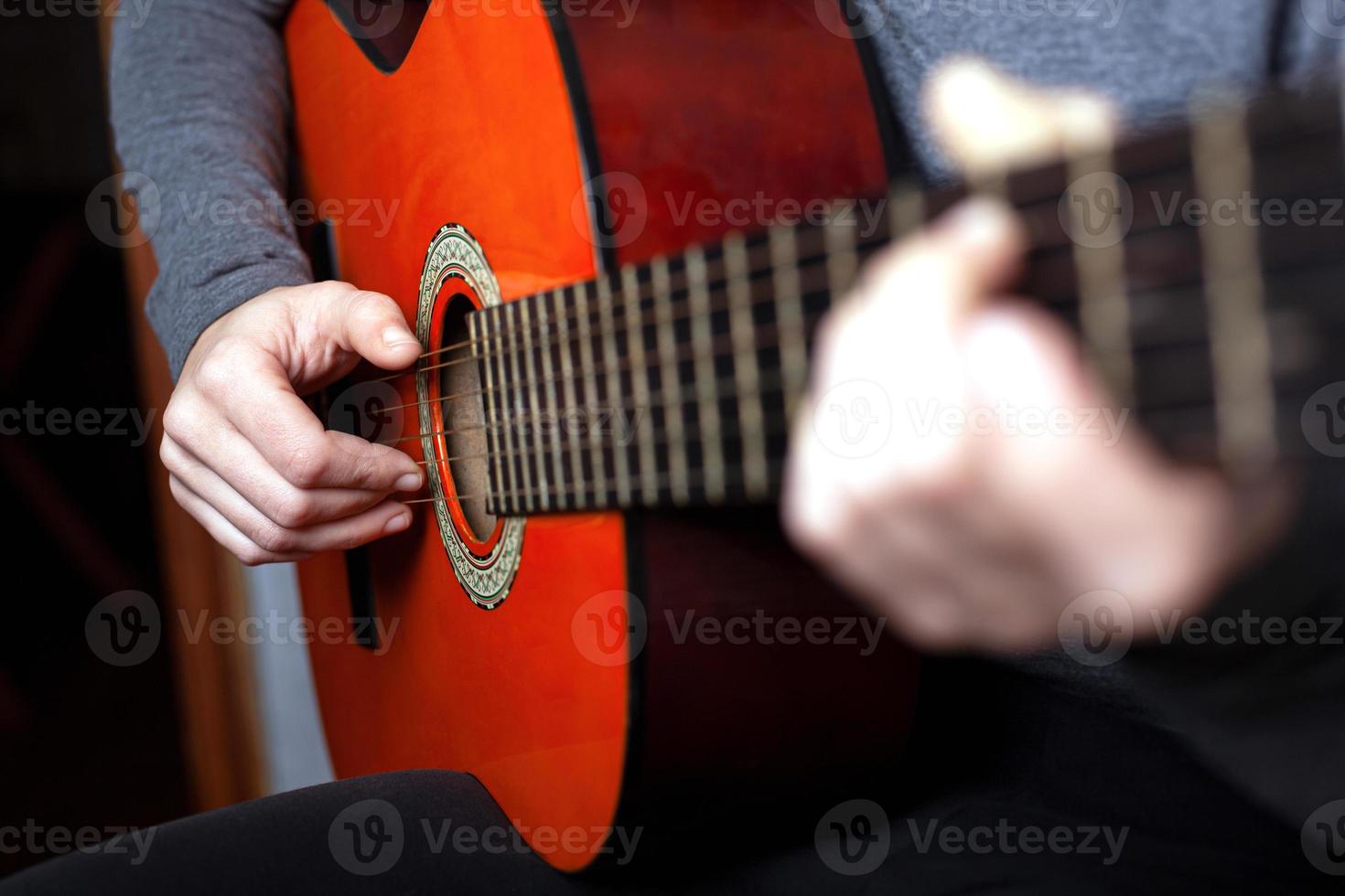 niña tocando una guitarra acústica foto