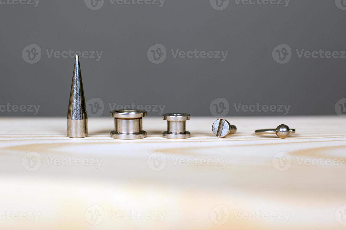 Set of accessories for piercing on a wooden board photo