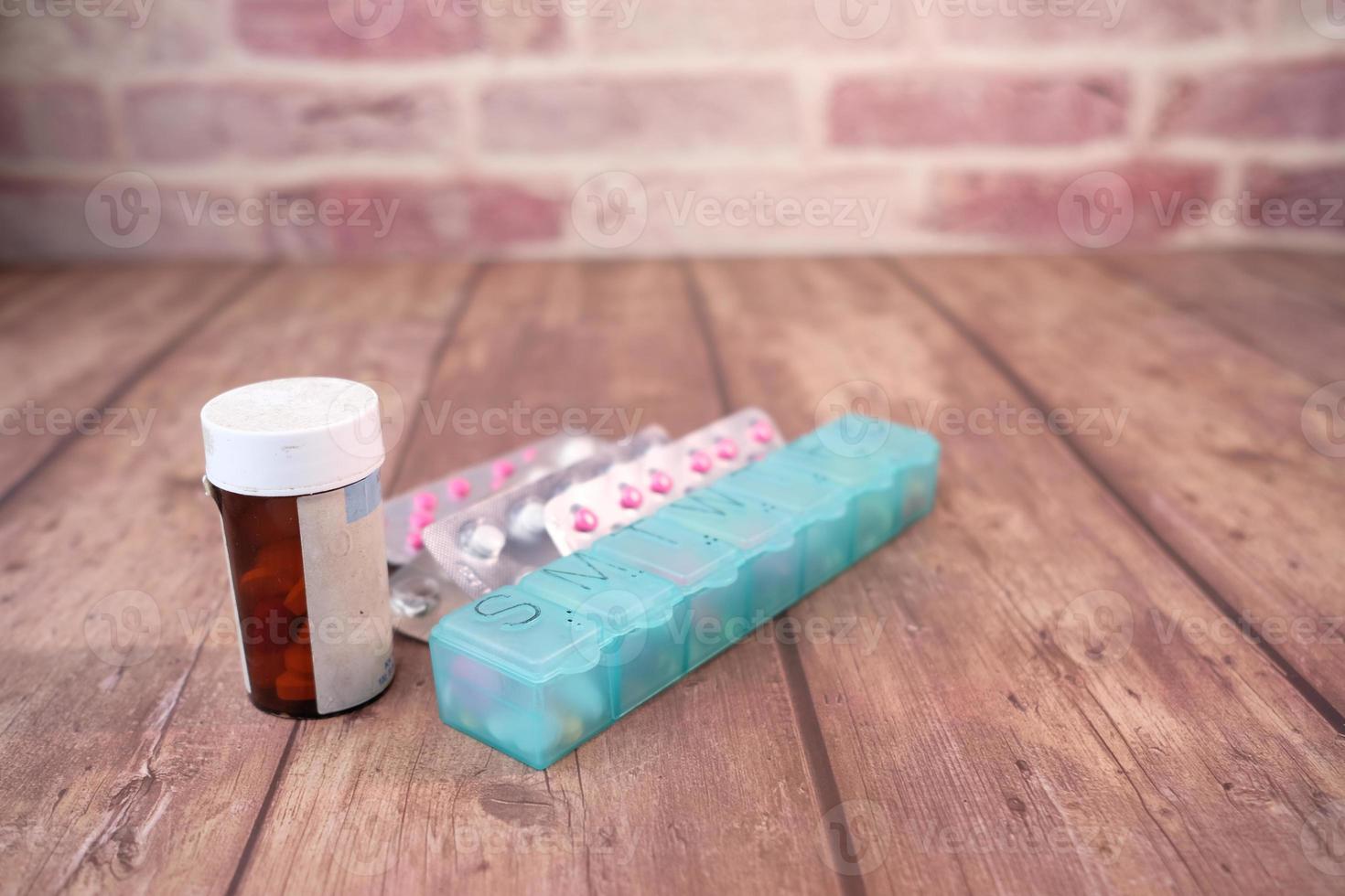 Close up of container, pill box, and blister pack on table photo