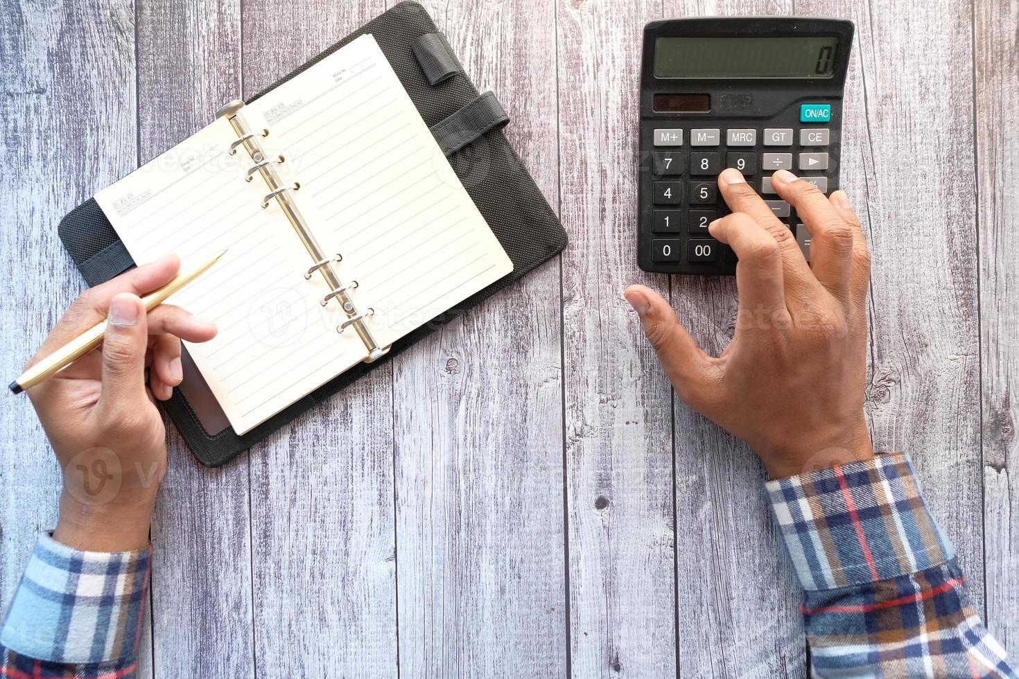 Close up of man hand using calculator photo