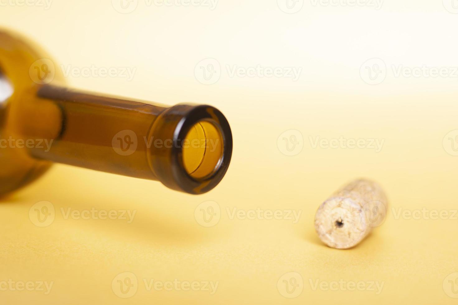 Empty bottle of wine close-up on a yellow background photo