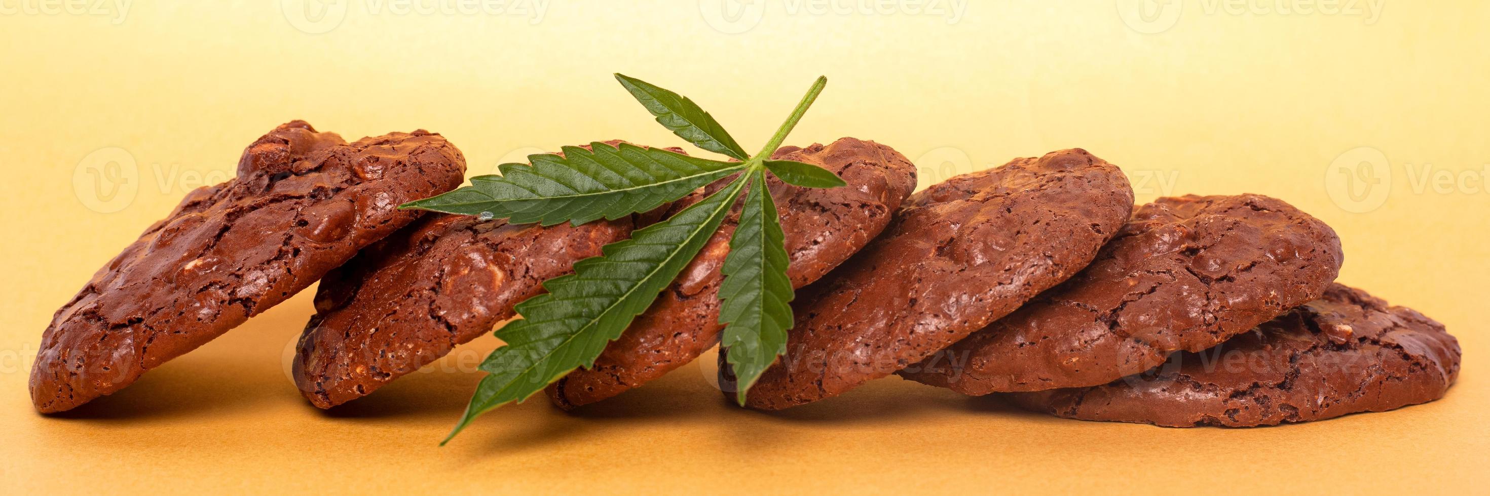 Marijuana oatmeal cookies and green leaf of cannabis on a yellow background photo