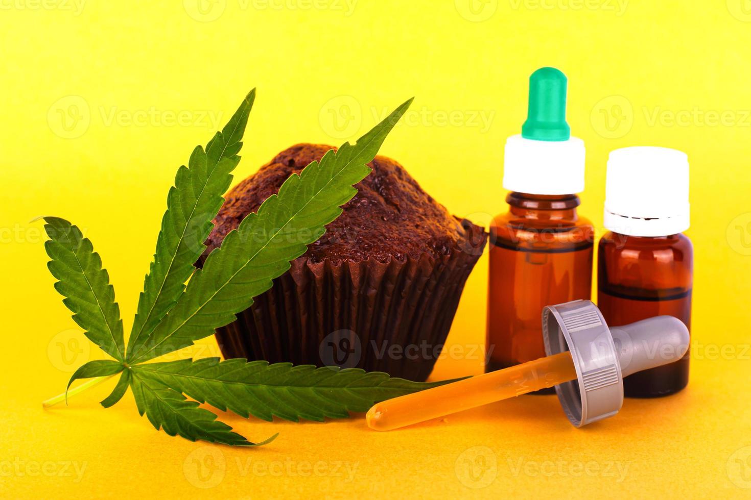 Brownie cake and green leaf marijuana with THC extract on a yellow background photo