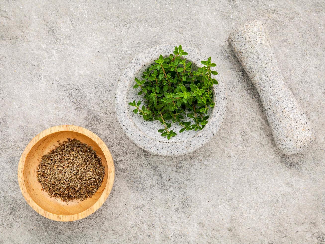 Close up of lemon thyme leaves in a white mortar and pestle set up on a stone table. Thymus citriodorus lemon thyme or citrus thyme species of flowering plant in the family Lamiaceae photo
