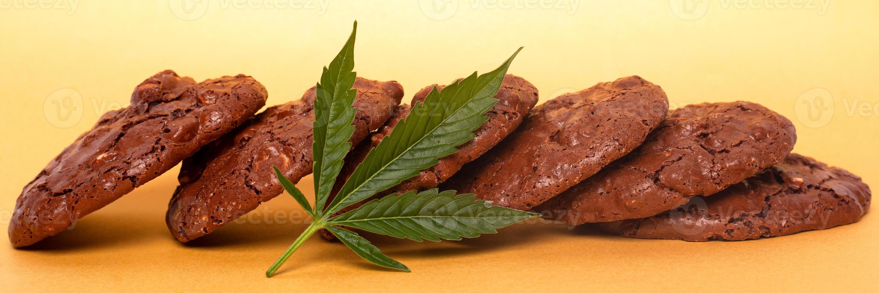 Cannabis cookies and green leaf on a yellow background photo