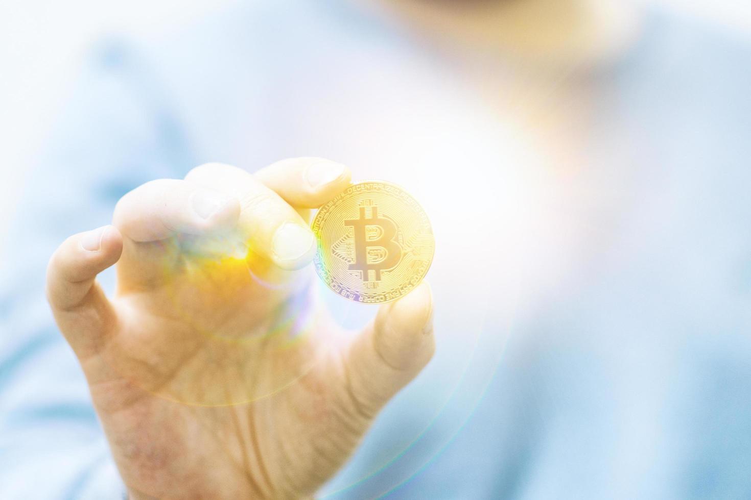 Man holding bitcoin in the hand photo