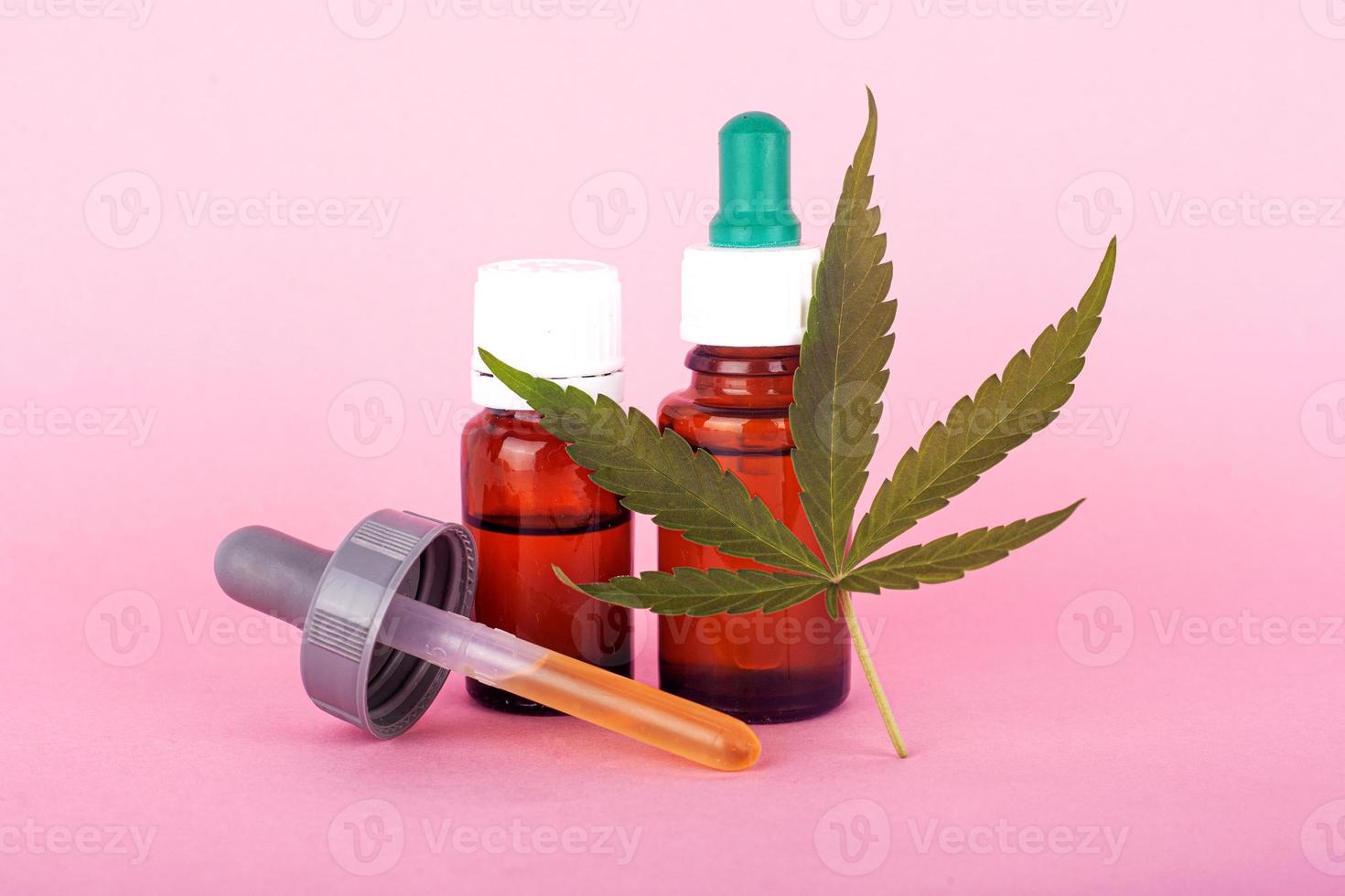 Medicina natural de cannabis, extracto de aceite de marihuana sobre fondo rosa foto
