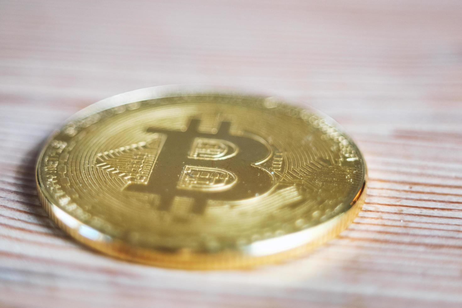 Close up of a Bitcoin cryptocurrency coin on a wooden background photo