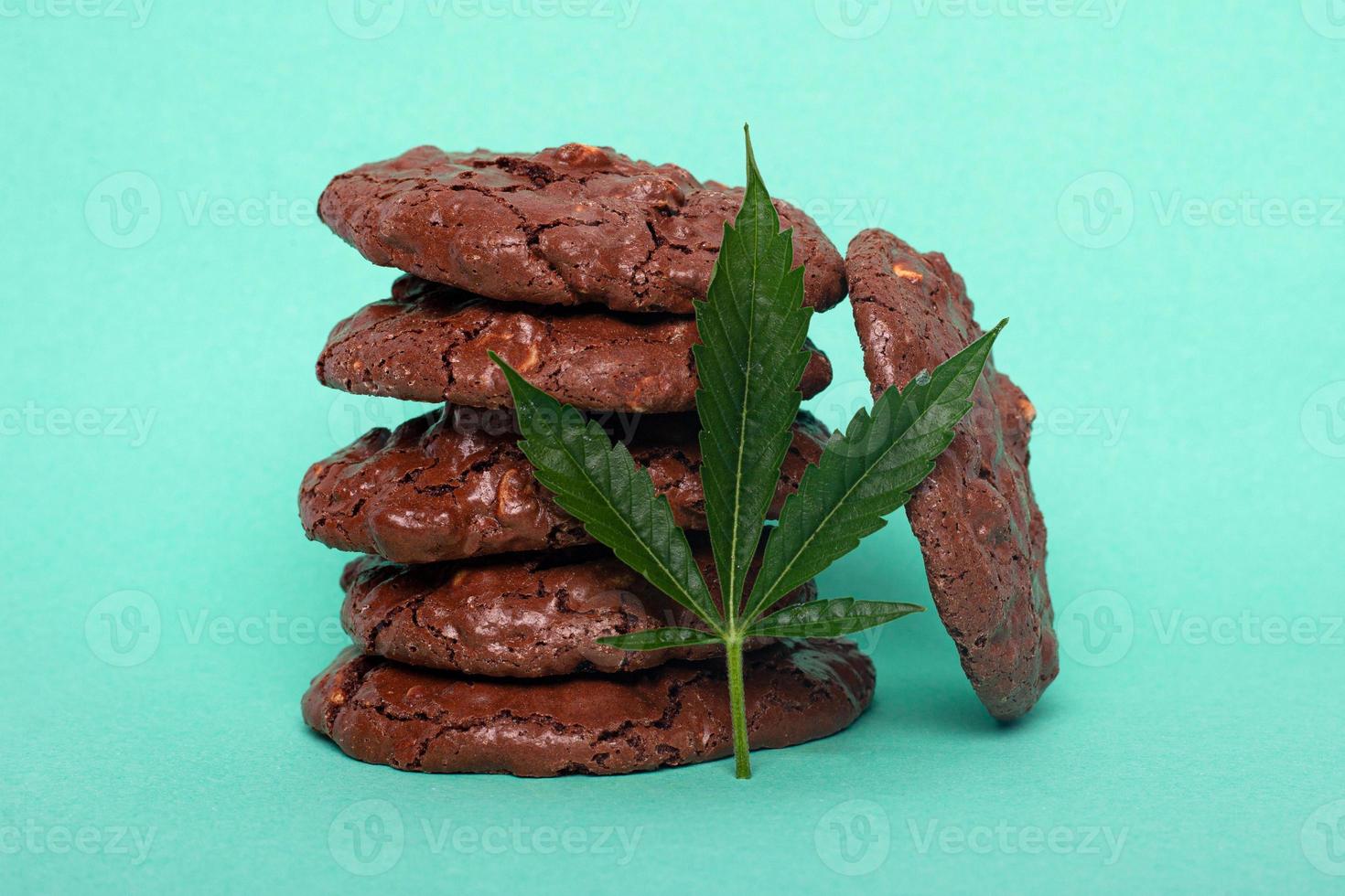 Glazed cookies with peanuts and cannabis on blue green background photo