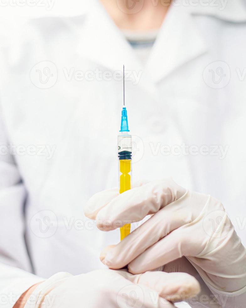 virus pandémico covid-19 doctor en blanco sosteniendo una jeringa de vacuna foto