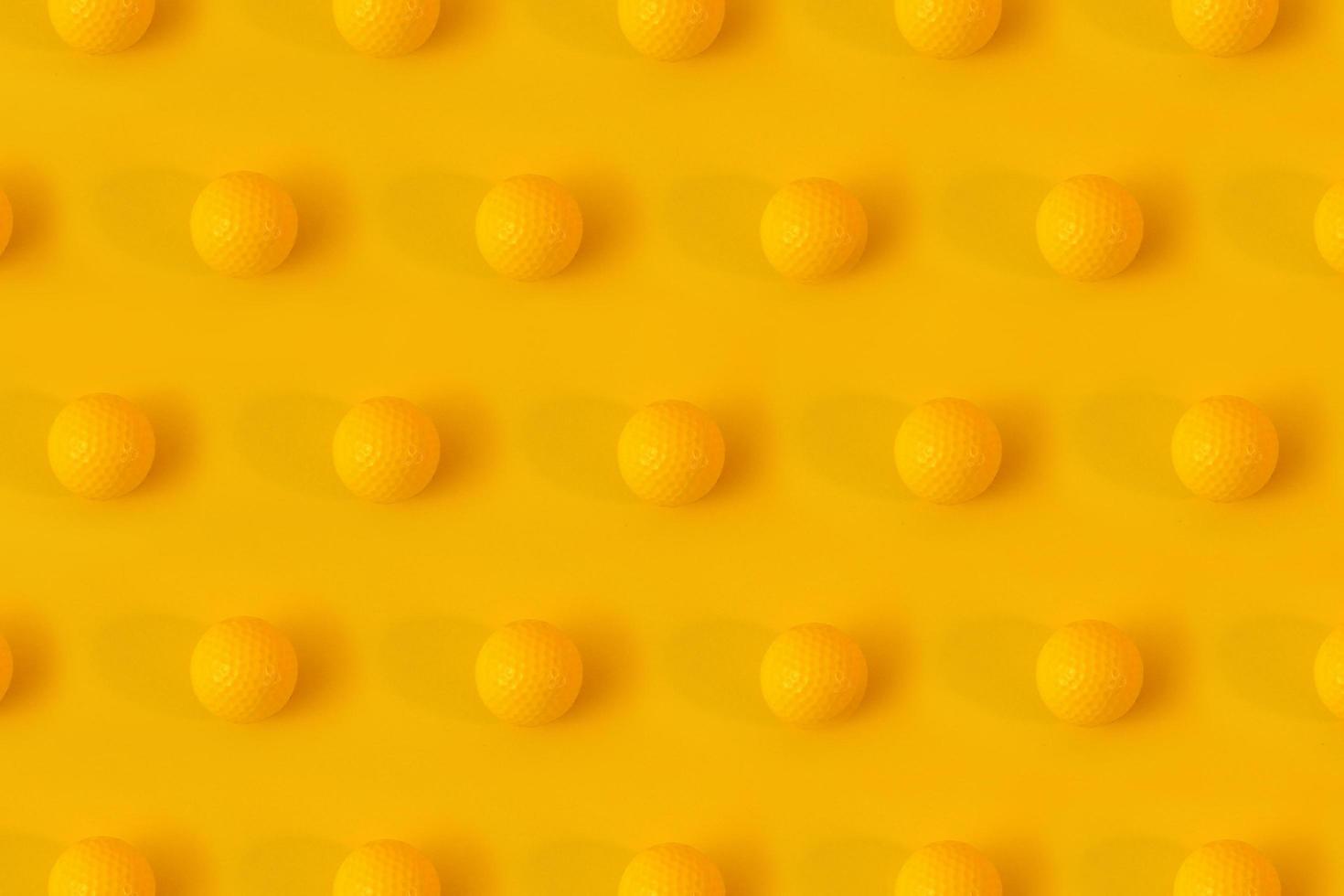 Yellow golf balls on yellow background creative concept. Monochrome color scheme. Repetitive texture pattern. photo