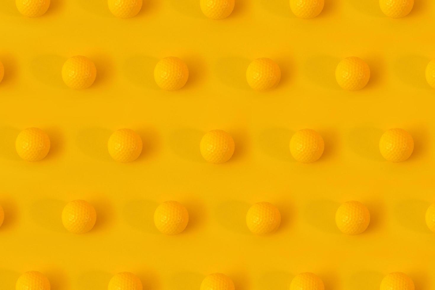 Yellow golf balls on yellow background creative concept. Monochrome color scheme. Repetitive texture pattern. photo